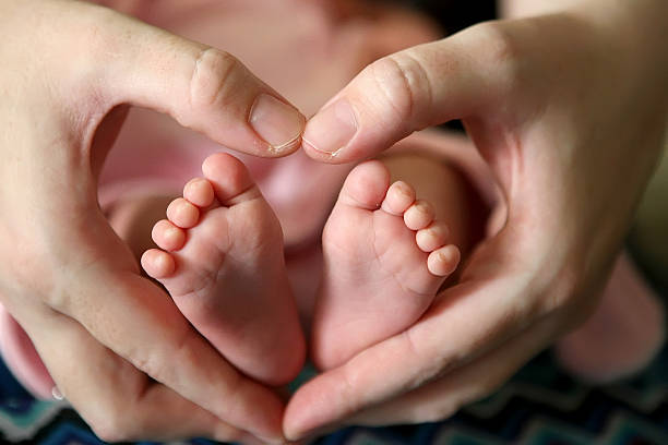 istock Baby's feet in mom's palms 507488083