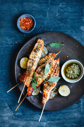 Salmon satay with pesto and chili sauce and herbs