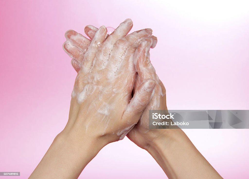 Woman washes her hands Woman washes her hands on a pink background Adult Stock Photo