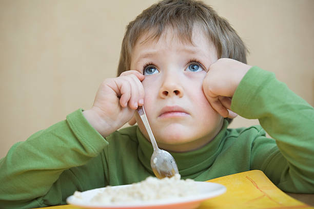 istock Unhappy Boy With Food Looking Up At Table 507491927