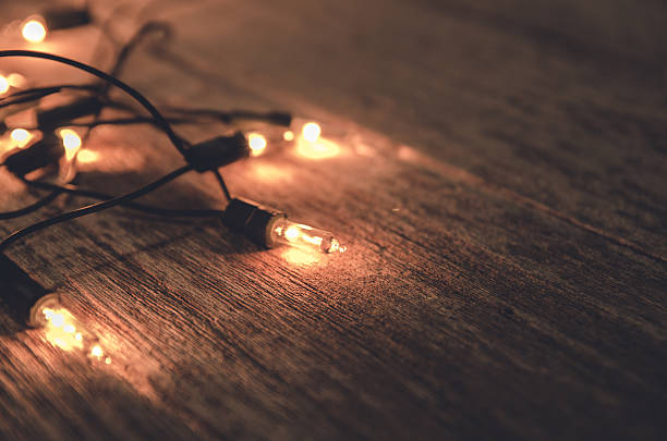 istock christmas light decor on wood background , color filter vintage tone 507493164