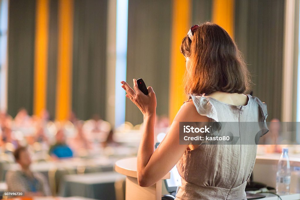 Speaker at Business Conference and Presentation. Female speaker at Business Conference and Presentation. Audience at the conference hall. Business and Entrepreneurship. Business woman. Horizontal composition. Laptop Stock Photo