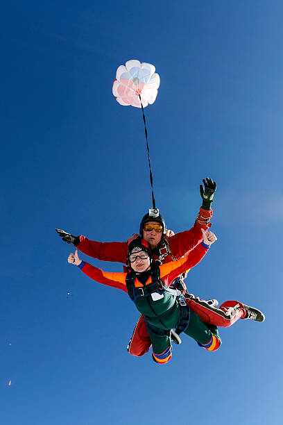 Skydiving photo. Tandem. A tandem jump instructor and a passenger in a free fall. parachuting stock pictures, royalty-free photos & images