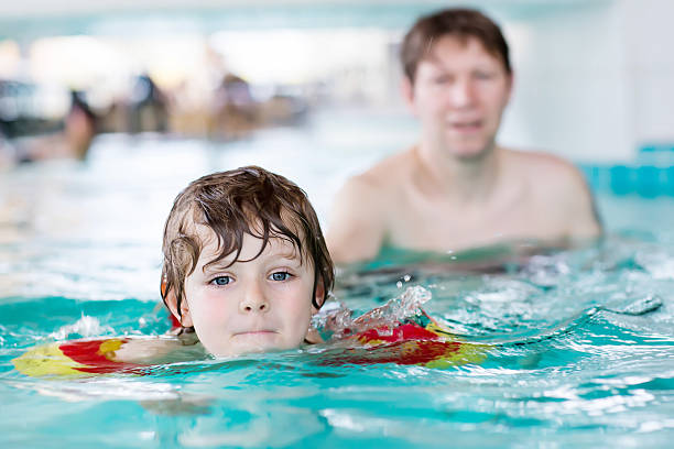 istock Young dad teaching his little son to swim indoors 507497258
