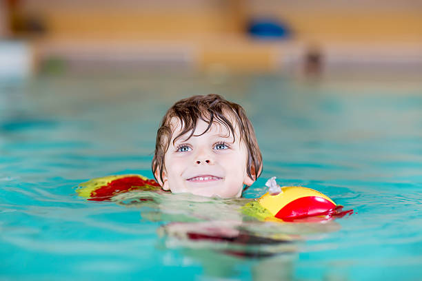 istock little kid boy with swimmies learning to swim  indoor pool 507497330