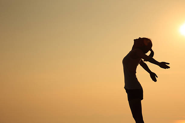 istock cheering woman open arms  at sunset 507509940