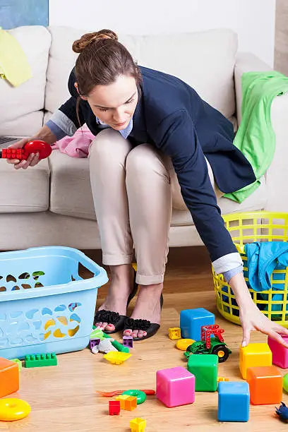 Photo of Working lady cleaning up toys