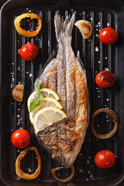 istock dorado fish with vegetables closeup on the grill. Vertical 507513482