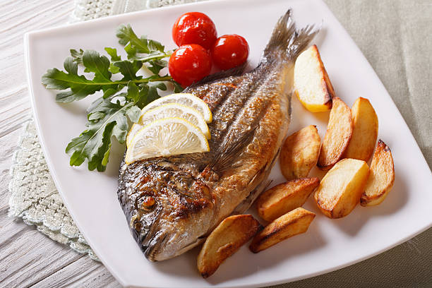istock dorado fish with fried potatoes and lemon closeup. horizontal 507515358