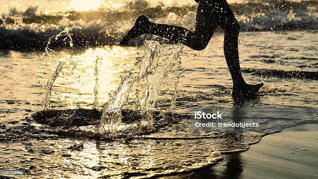 By the Sea - Running on the Beach at Sunset By the sea - running on the beach at sunset Barefoot Stock Photo