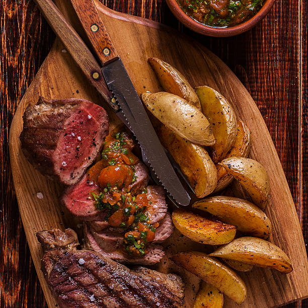 istock Grilled steak with potato wedges, salsa and spices. 507517182
