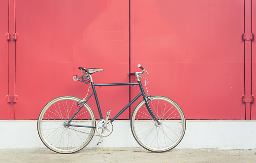 Vintage bicycle on red steel door background