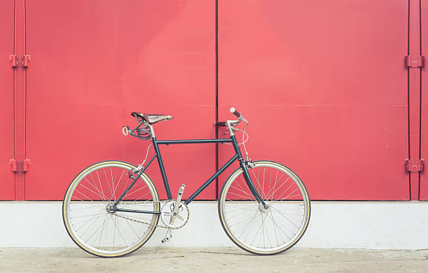 Vintage bicycle on red steel door background stock photo