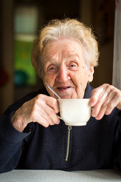 istock Old woman drinking tea, portrait close-up. 507519430