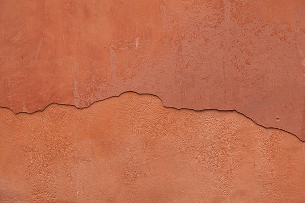 istock Old terracotta painted stucco wall with cracked plaster. Backgro 507525346