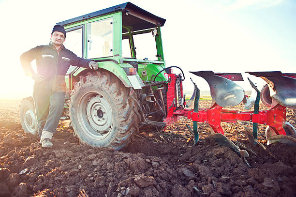 istock Farmer standing in front of tractor in a field 507530216