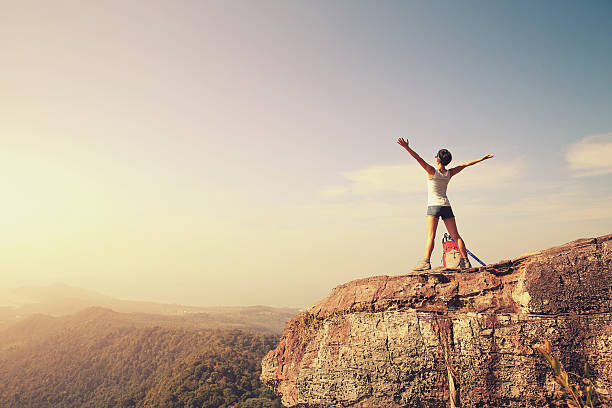 istock woman hiker enjoy the view on mountain peak cliff 507530320