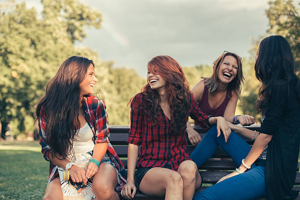 группа счастливый девочек сплетни в парке - teenager child student social gathering стоковые фото и изображения