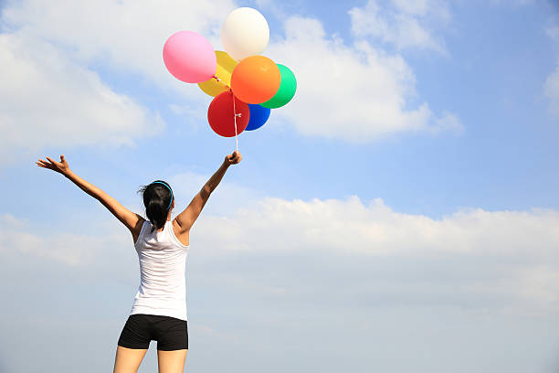 istock young asian woman with colored balloons 507532432