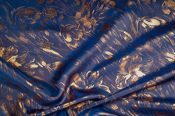 istock Fabric texture of silk with gold-painted flowers 507533716