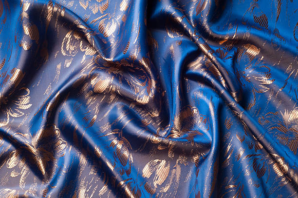 istock Fabric texture of silk with gold-painted flowers 507533818