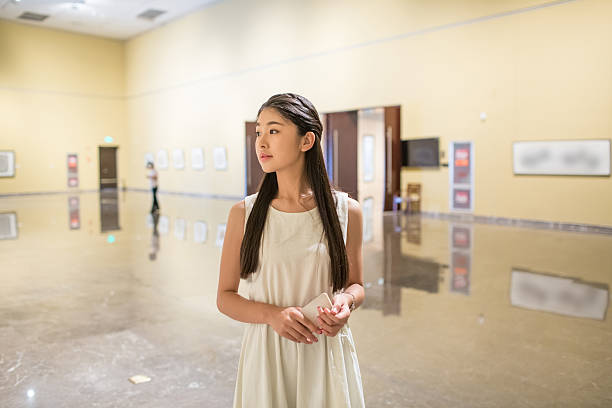 pretty young chinese girl, alone in the museum visit china painting exhibition.