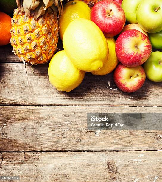 Apples Citrus And Pineapple Make Top Border On Wood Stock Photo - Download Image Now