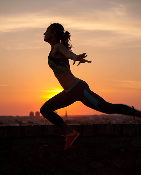 silhouette der mädchen stretching-bei sonnenaufgang oder sonnenuntergang - heaven women sunrise inspiration stock-fotos und bilder