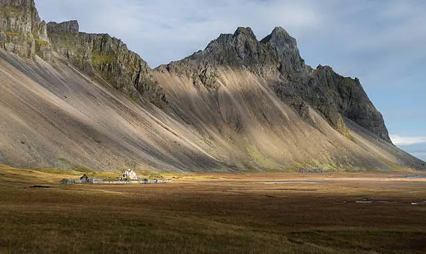 Abandon cottage when touch the light in yellow field with mountain range background Autumn season  Vesturhorn Iceland