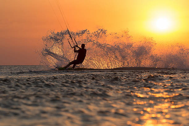 kiter's  trick professional kiter makes the difficult trick on a beautiful background of spray and colourful sunset of Black sea kiteboarding stock pictures, royalty-free photos & images