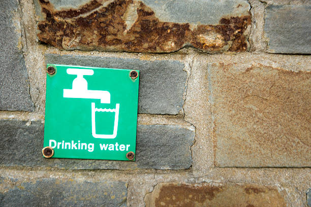 istock Background image Old stone wall with Drinking Water sign 507548436