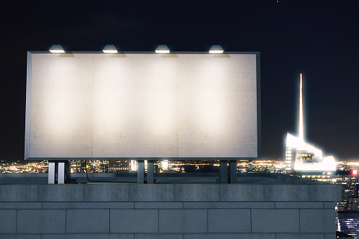 Big empty billboard on the background of the city at night, mock up
