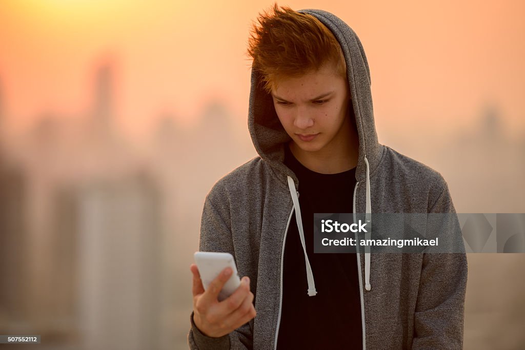 Teenager boy outdoors mit Handy - Lizenzfrei Männlicher Teenager Stock-Foto