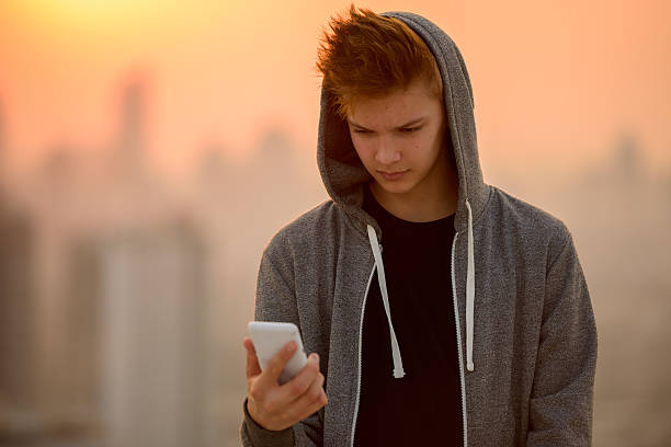 Teenager boy outdoors using mobile phone Handsome teenager boy outdoors using mobile phone one teenage boy only stock pictures, royalty-free photos & images