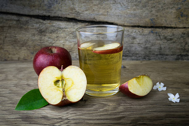 istock Apple juice and apples on a wooden table 507554200