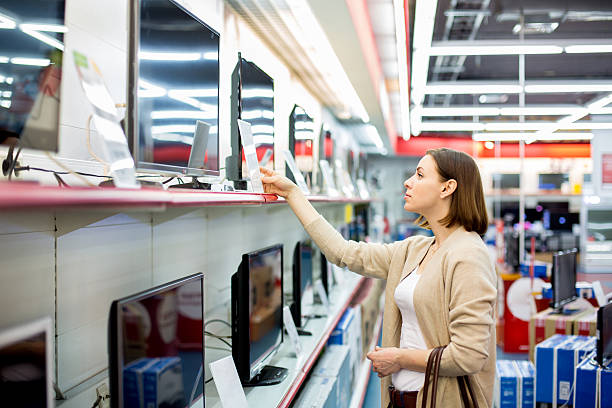 mujer compra el televisor - aparatos electricos fotografías e imágenes de stock