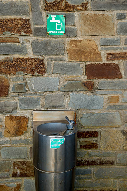 istock Old stone wall with Drinking Water fountain 507567280