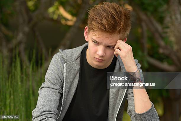 Sad Teenager Boy Outdoors Alone Stock Photo - Download Image Now - Teenage Boys, Sadness, 14-15 Years