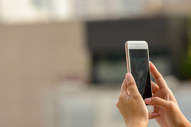 mano tomando mujer mediante teléfono móvil al aire libre - mensaje de móvil fotografías e imágenes de stock