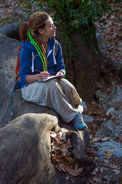 istock Cute Girl sitting in Forest and drawing sketch note book 507571532
