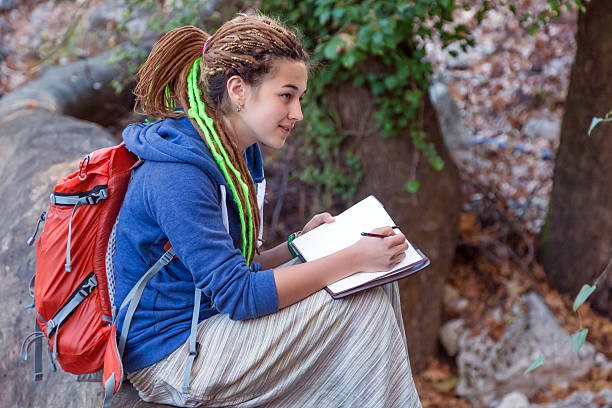 istock Cute Girl sitting in Forest and drawing sketch note book 507571810