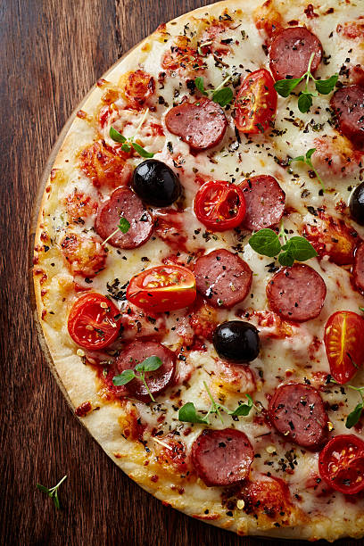 Pizza with pepperoni and cherry tomatoes stock photo