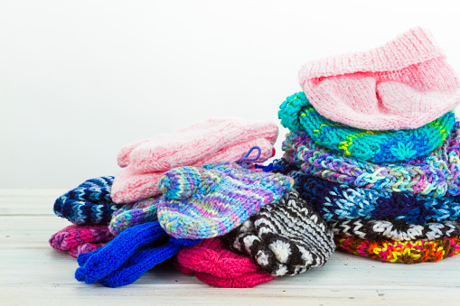 Colourful woollen winter socks with Christmas decorations  and Winter berries on a wood background.