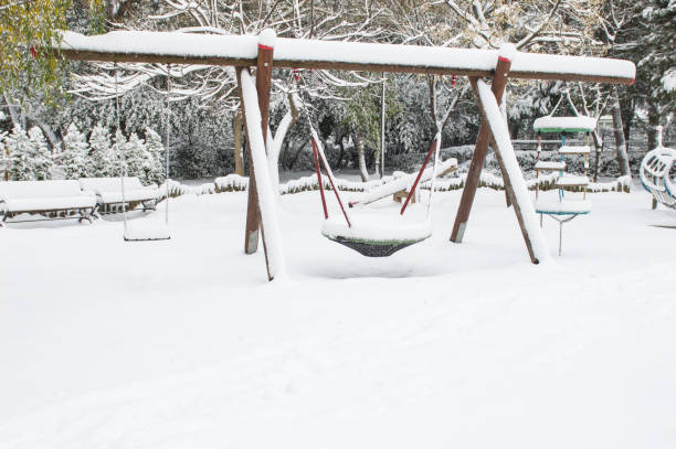 istock snow covered swing at playground in winter 507574166