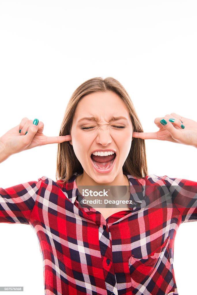 Close up photo of angry girl screaming Close up photo of angry girl screaming and closing her ears Accessibility Stock Photo
