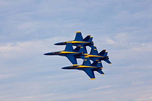 US Navy Blue Angels flying in formation Pensacola, USA - November 12, 2011: US Navy Blue Angels flying in formation on November 12, 2011 during the Blue Angels Homecoming Air Show at NAS Pensacola. Blue Angels fly F-18 Hornets with special livery representing colors of US Navy: Yellow and Navy Blue. US Navy Blue Angels is the oldest active military aerobatic demonstration squadron and is considered the best Demonstration Squadron in the world. supersonic airplane editorial airplane air vehicle stock pictures, royalty-free photos & images