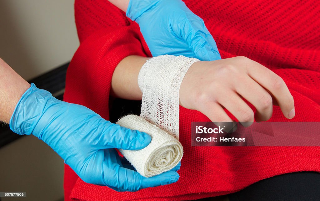 Jeune fille patient étant examiné par infirmière Auxiliaire médical - Photo de Trousse de secours libre de droits