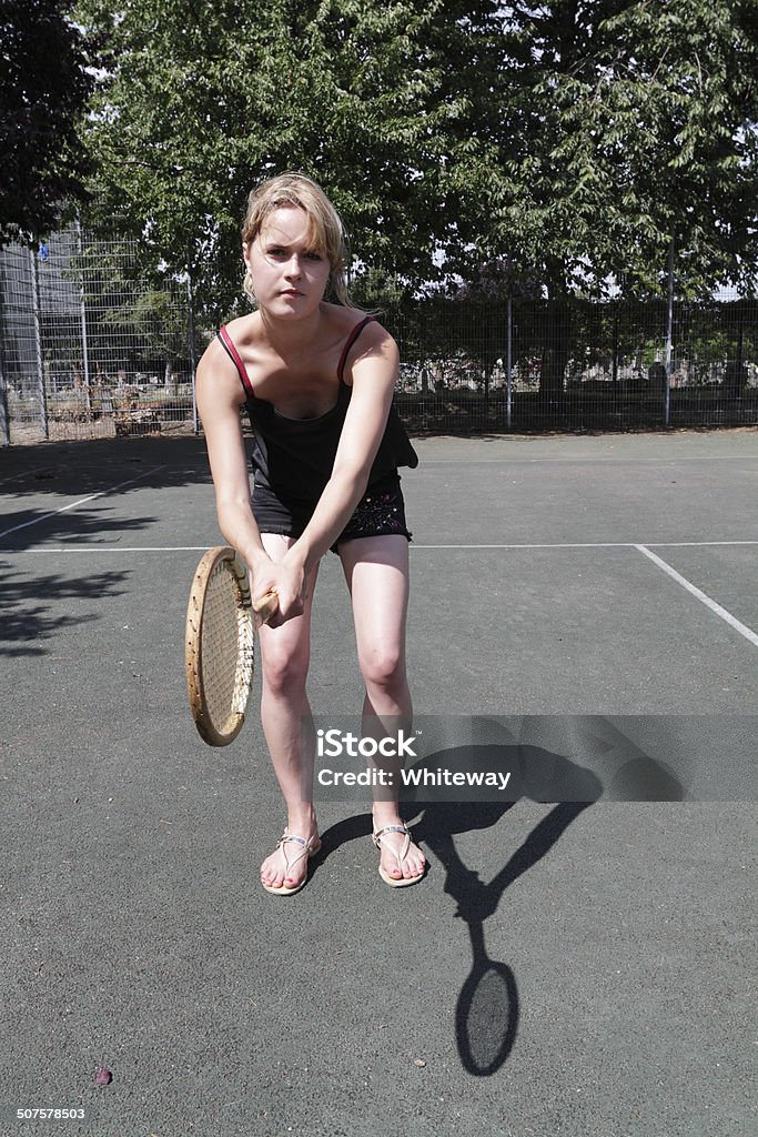 Tennis ready position with outdoor girl and wooden racquet Outdoor girl model demonstrates the ready position with a heavy wooden tennis racquet made in around 1930. Sport on a public tennis court in Mitcham, Surrey. The ready position is the position adopted by a tennis player about to receive serve. Outdoor girl – more photos of the same model: . Surrey - England Stock Photo