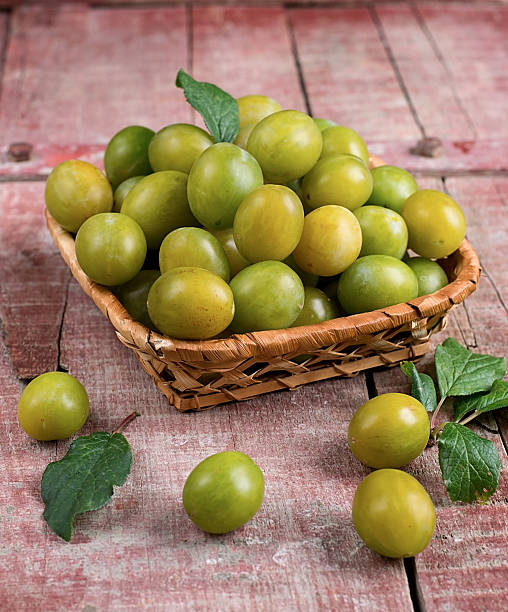 istock Yellow plums in a basket on wooden background 507578633
