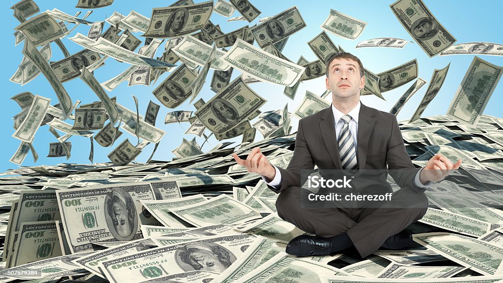 Businessman sitting in lotus posture Businessman sitting in lotus posture on pile of cash Adult Stock Photo